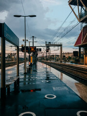An empty railway station in the evening on a rainy gloomy day, puddles on the asphalt, dampness. Europe, France