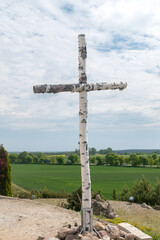 Birch cross next to statue of Christ the King in Swiebodzin.