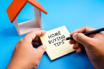 Top view of toy house and memo note written with Home Buying Tips.