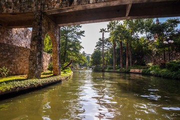 Fototapeta na wymiar View at San Antonio river and a bridge in summer sunny day. Texas, USA