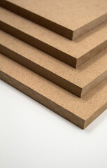 Four plates of raw brown MDF on a white background. Raw MDF can be used as a material in construction as a replacement for wood in non-load-bearing walls, ceilings, partition walls.