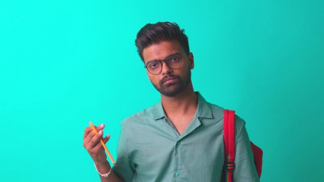 indian student man feeling inspiration idea wear eye glasses holding a pencil in blue studi
