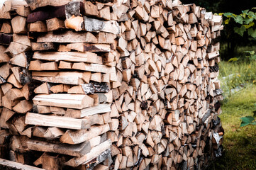a woodpile with harvesting and stacked firewood of chopped wood for kindling and heating the house....