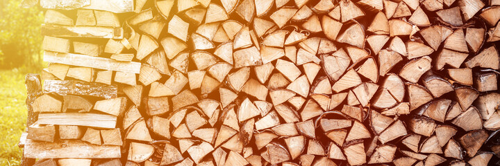 a woodpile with harvesting and stacked firewood of chopped wood for kindling and heating the house. firewood of the birch tree. banner.. flare