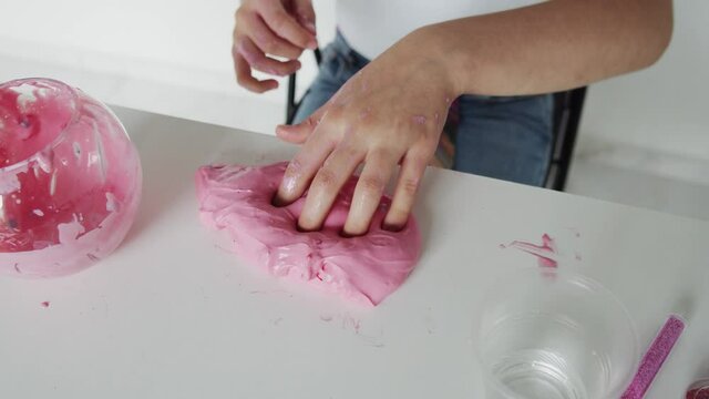 Close up camera view of pink slime in hands