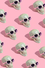 Skull pattern with glasses on pink background. Halloween creative fashion love concept.