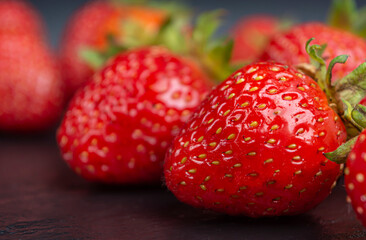 red ripe strawberries on a black background close up