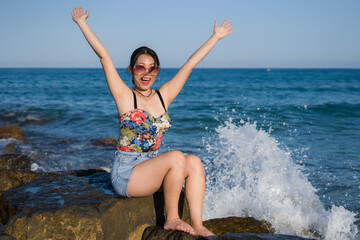 young Asian woman by blue sea -  happy and beautiful Chinese girl  enjoying holiday trip relaxed and cheerful at beach rock cliff during summer in tourist  travel concept