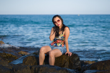 young Asian woman by blue sea -  happy and beautiful Chinese girl  enjoying holiday trip relaxed and cheerful at beach rock cliff during summer in tourist  travel concept