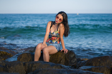 young Asian woman by blue sea -  happy and beautiful Chinese girl  enjoying holiday trip relaxed and cheerful at beach rock cliff during summer in tourist  travel concept