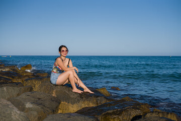 holidays lifestyle portrait of young Asian woman by the  sea -  happy and beautiful Korean girl  enjoying beach vacation trip relaxed and cheerful at beach rock cliff