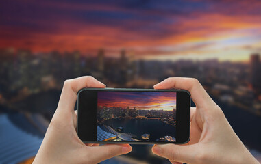 Taking photo on smart phone concept.Singapore city in sunset time