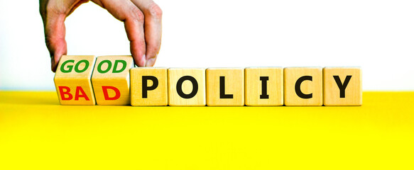 Good or bad policy symbol. Businessman turns wooden cubes and changes words 'bad policy' to 'good...