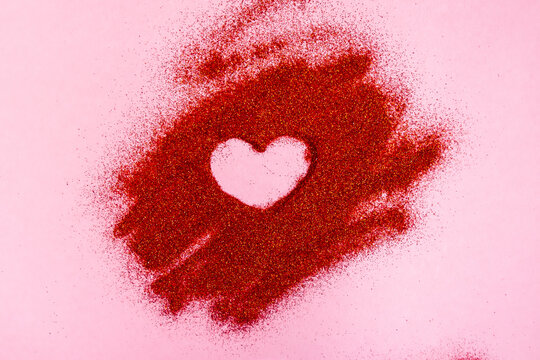 Valentine's Day concept. Heart shaped painted by on red glitter. - Powered by Adobe