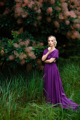 Obraz na płótnie Canvas Girl model blonde in a lilac dress with a bouquet
