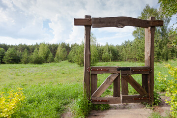 Wooden closed gates to the meadow, the passage is closed