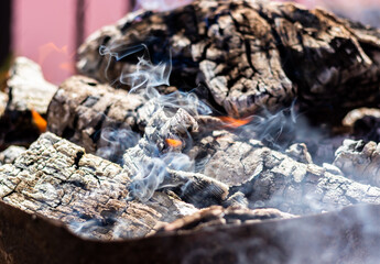 The texture of hot coals, embers and ashes left over from the burned wood, but which still burns smoldering with flame and smoke