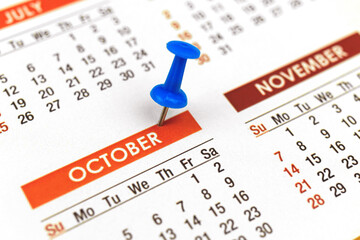 Calendar with push pin, october month close-up, planner concept, selective focus photo