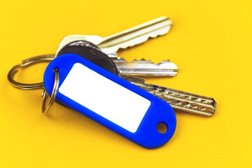 Keys with mockup plastic badge with copy space, concept of new property purchasing, yellow background