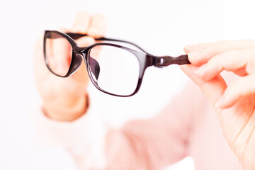 glasses in women's hands close-up, white background