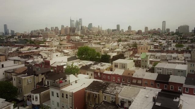 Aerial view across Philadelphia colourful residential rooftops city landscape descending to historic downtown street scene