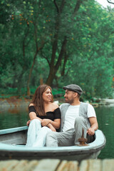 Couple looking at each other sitting in a boat in the middle of a lake