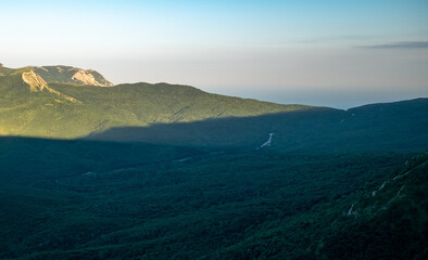 Pid to the surrounding mountains from the lower plateau of Chatyr-Dag in Crimea in the light of the setting sun.