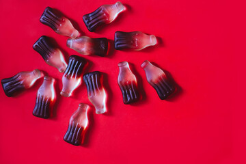 Red background with many cola gummy candies