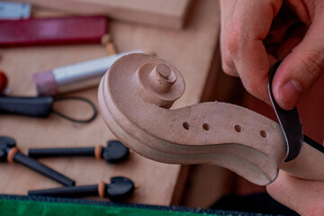 Process where luthier's hands  make a final details of violin 