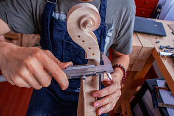 Process where luthier's hands  make a final details of violin 