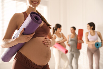 Group of pregnant women with mats in yoga class, closeup. Space for text