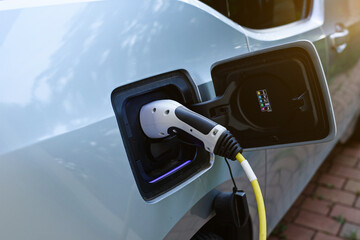 Power supply joined to modern electric car being charged.