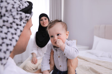 Fototapeta na wymiar Happy Muslim family with little son in bedroom
