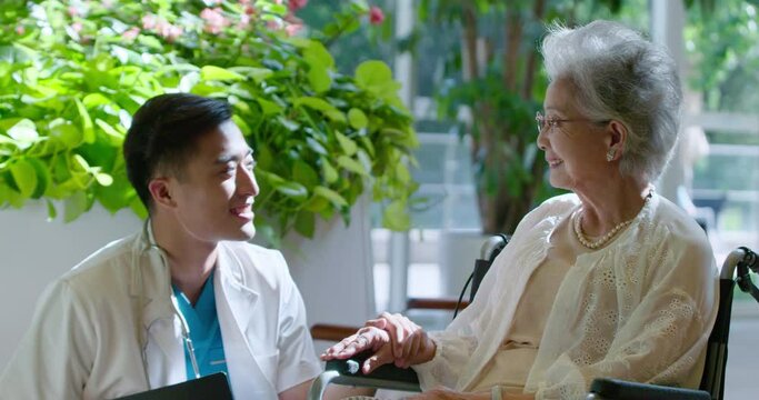 Young doctor talking with senior man in nursing home,4K