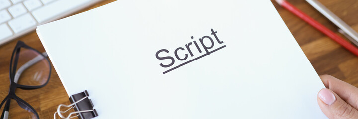 Female hands holding script over table closeup
