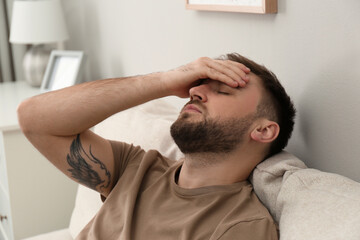 Young man suffering from migraine at home
