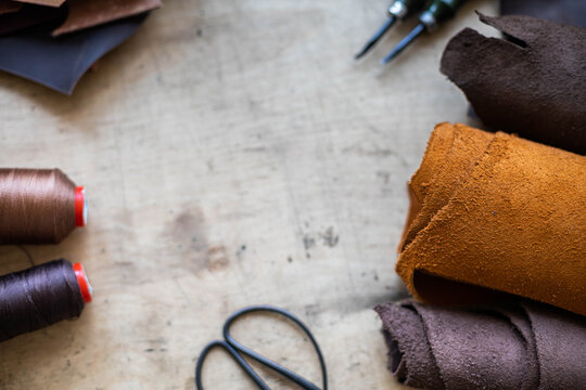 Top view wooden table surface copyspace with materials, instruments. Leather workshop