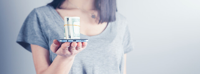 girl holding a phone and money