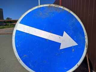 temporary road sign white arrow on a blue background pointing diagonally to the right.