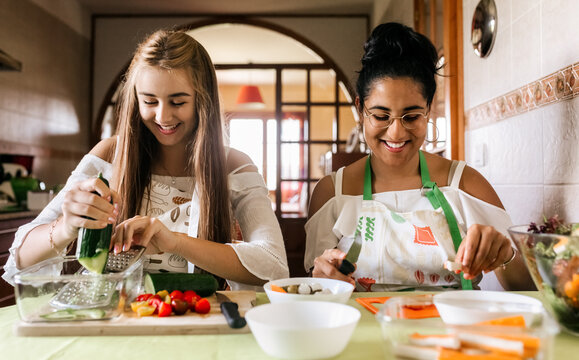 Two young friends cooking at home