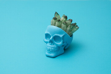 Blue human skull with healing mineral ore crystals