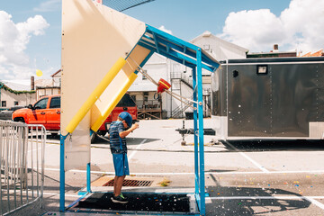 Child being splashed with water balloon. 