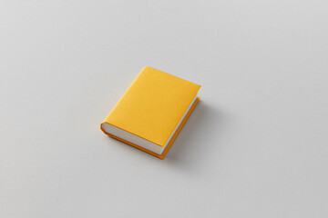 Yellow papercraft book on gray background