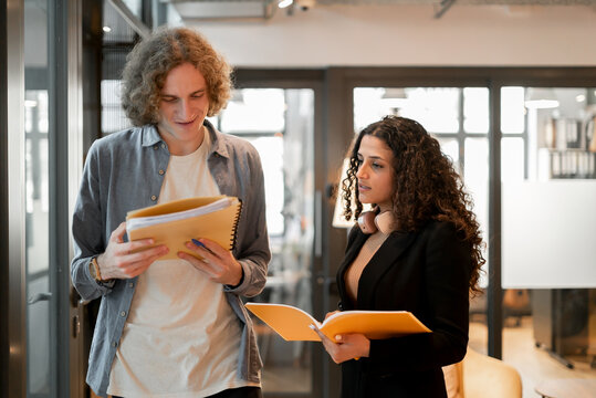 Two coworkers talking and sharing ideas in a co-working place.