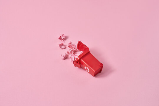 Crumpled papers in red trash can