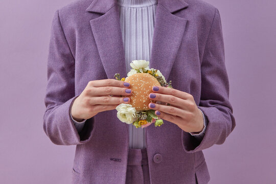 Woman standing with burger with peonies