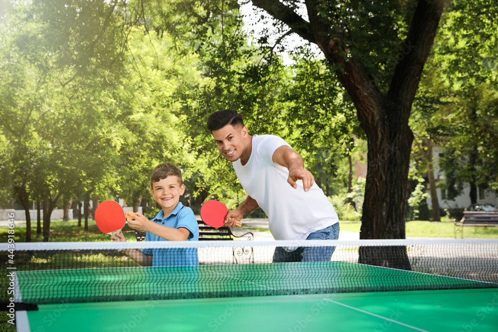 Sticker Man with his son playing ping pong in park