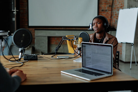Podcaster discussing theme with coworker 
