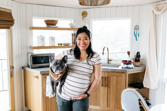 Portrait of a pregnant woman holding her dog