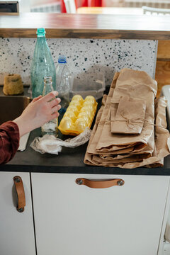 Woman sorting various waste for recycling at home